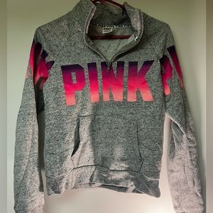 Pink & purple gradient pink logo with a dotted grey background and is 3/4 zip up